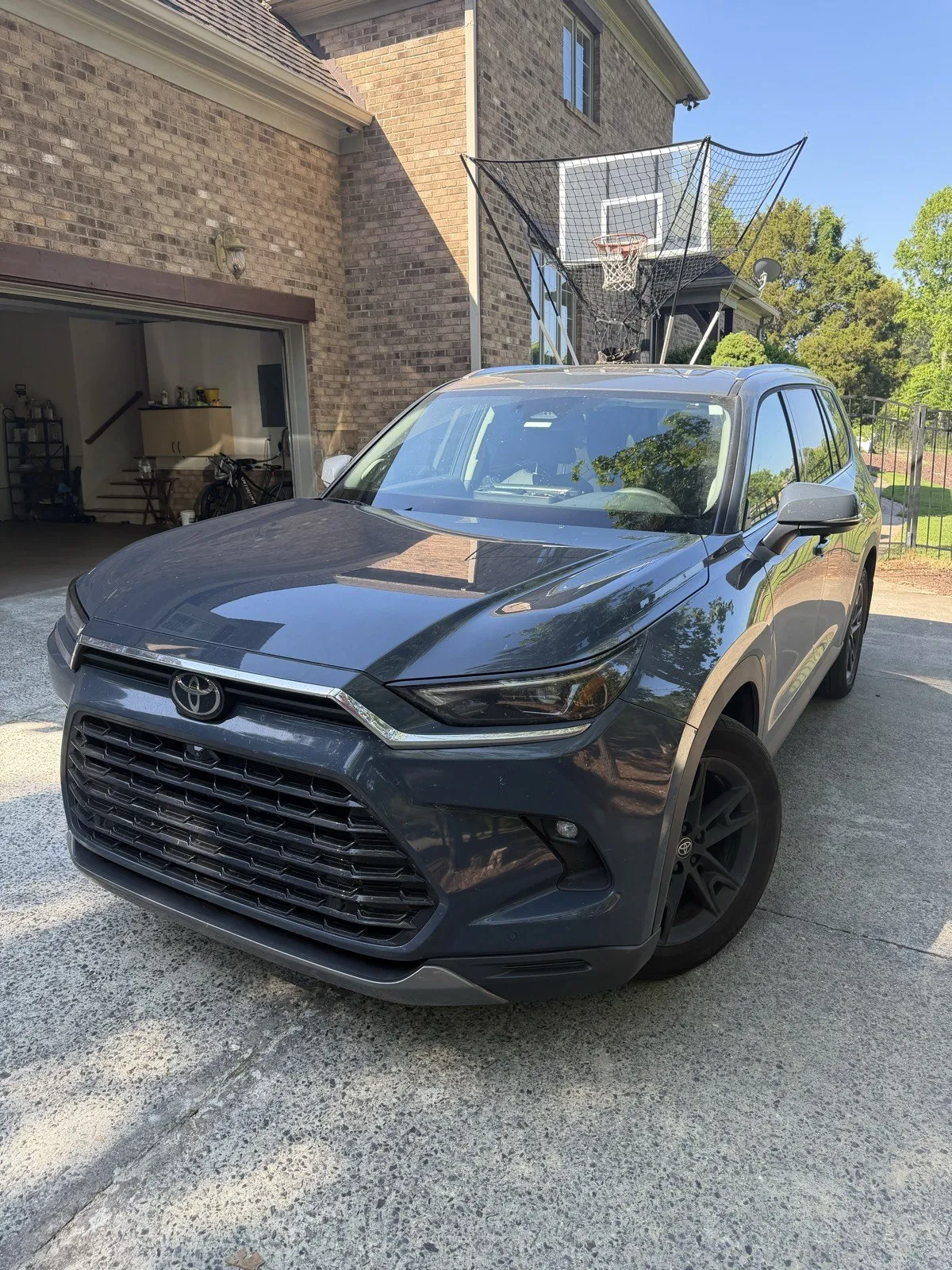 A dark grey Toyota Grand Highlander on a driveway after a full detail