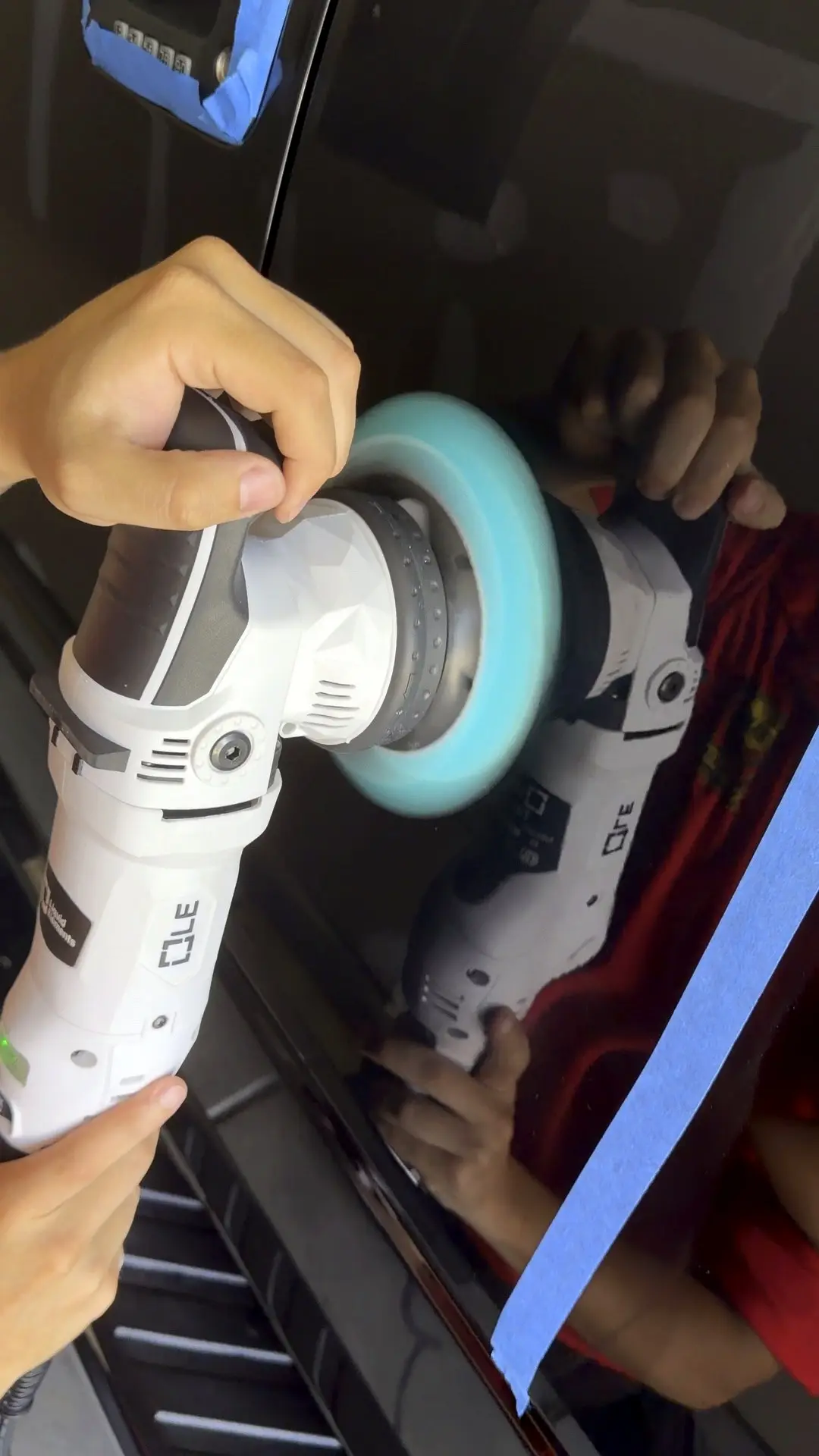 A dual action polisher working a panel during paint correction